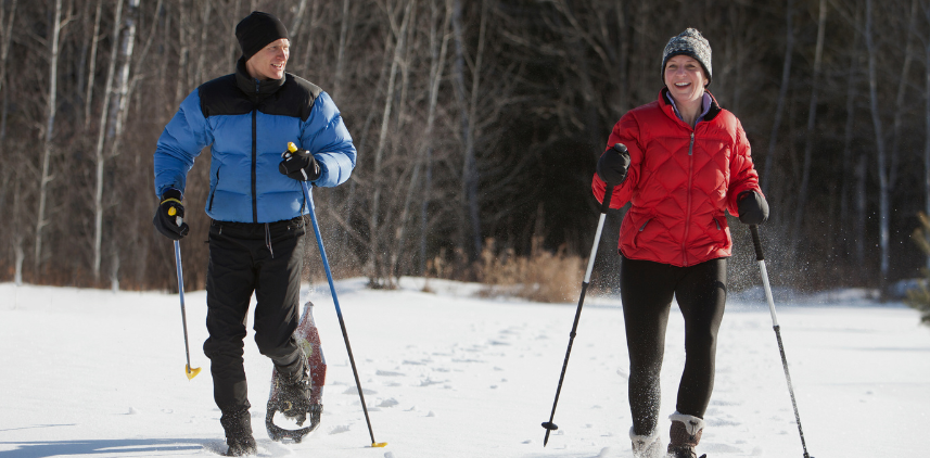 two people in the open snow, snowshoeing. 